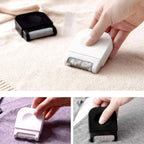 Portable lint remover with ergonomic grip, shown on a fabric surface.