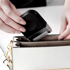 Handheld fabric shaver removing lint from a grey sweater.