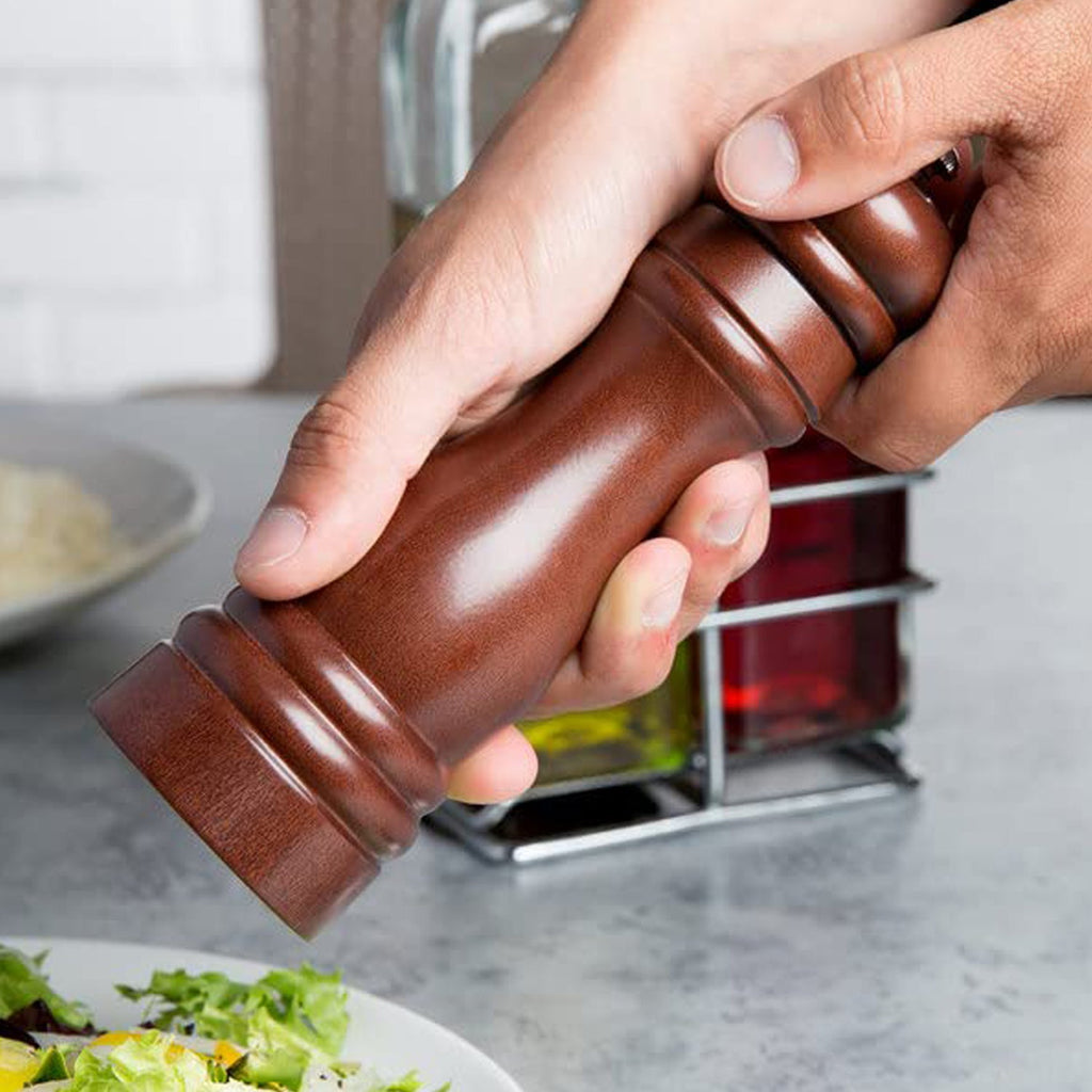 Stylish wooden pepper mill positioned alongside fresh spices in a modern kitchen setting.