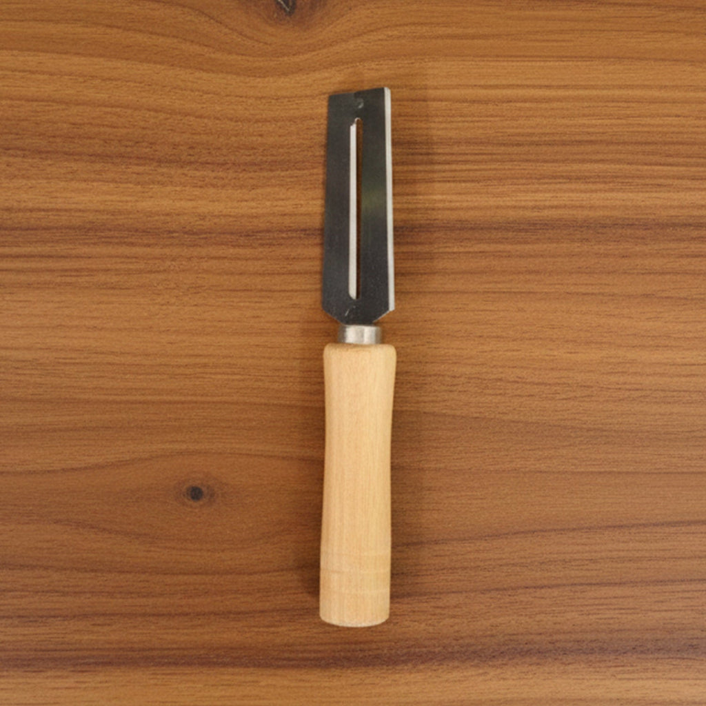Sharp stainless steel blade of multipurpose vegetable peeler clearly visible