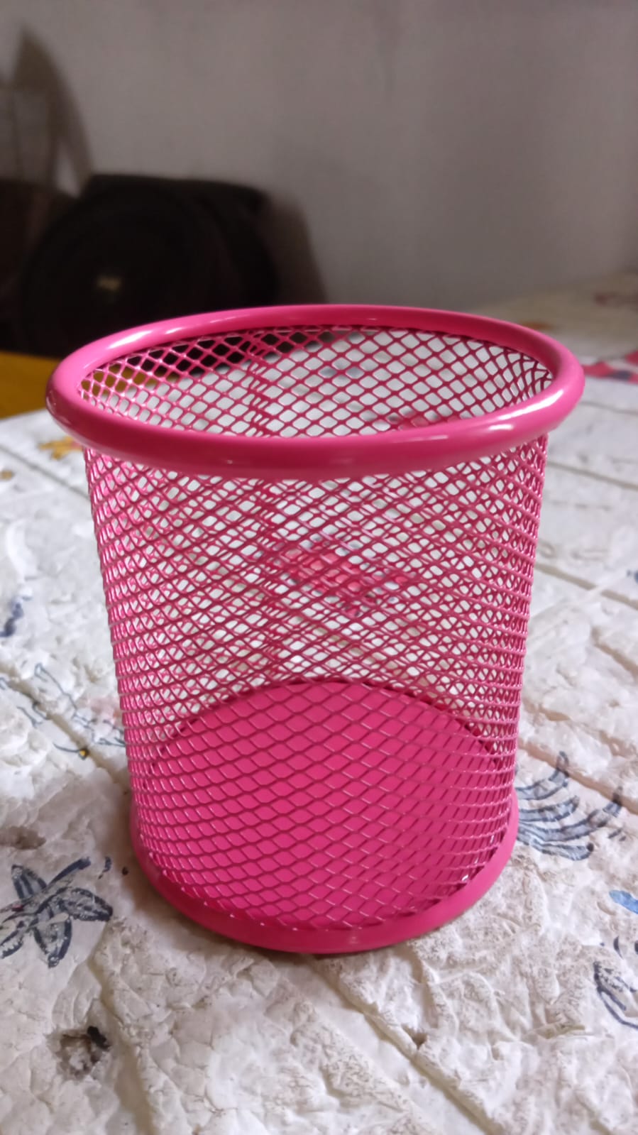 Lifestyle shot of the metal mesh desk organizer holding pens and markers.