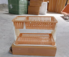 Modern black dish rack with various kitchen utensils draining into a tray.