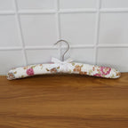Close-up of floral bow detail on premium satin-padded clothes hanger