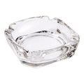 Elegant crystal glass ashtray with four cigar slots on a modern wooden table.