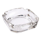 Elegant crystal glass ashtray with four cigar slots on a modern wooden table.