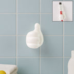 White hand-shaped wall clip holding keys and cables with thumb grip