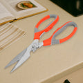 Multi-function kitchen scissors with a magnetic sheath for safe storage on a kitchen counter.