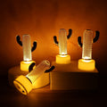 Set of four Cactus Shaped Flameless LED Candles displaying a warm, flickering glow against a dark background.