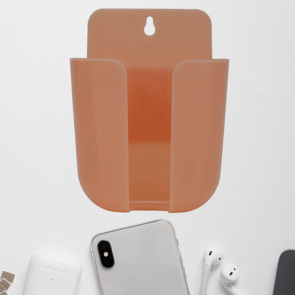 Wall mounted phone holder with a charging port in a modern living space.