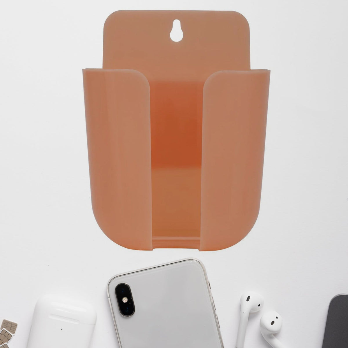 Wall mounted phone holder with a charging port in a modern living space.