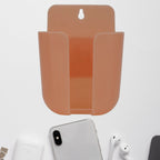 Wall mounted phone holder with a charging port in a modern living space.