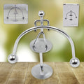 A chrome Mini Steel Balance Toy in a weightlifter pose, ideal for desk decor.