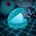 A glowing Pearl Shell Night Lamp on a light-colored surface, showcasing its unique design.