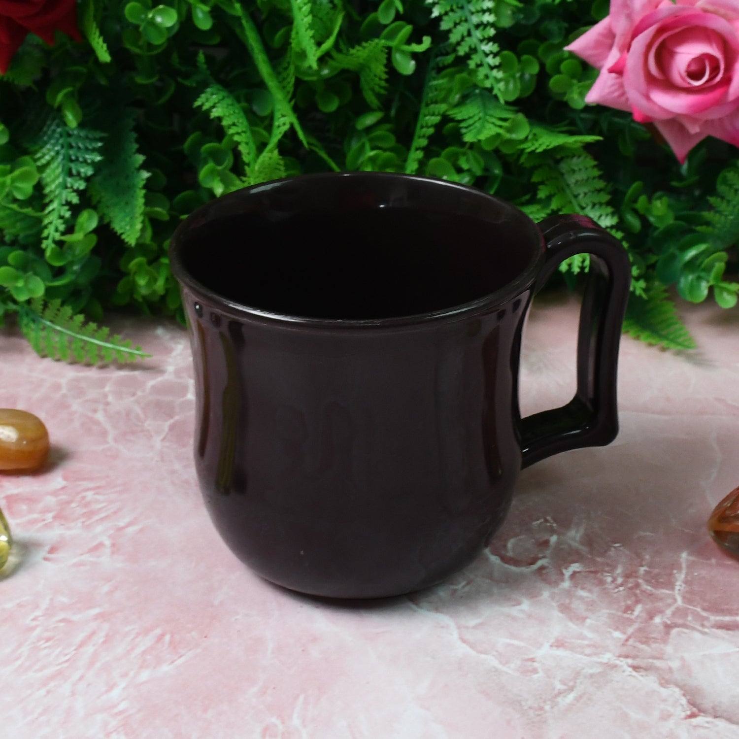 Top-down view of a black plastic coffee mug, revealing its wide mouth for easy cleaning.