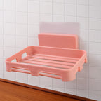 Self adhesive soap dish holder with open slatted design mounted on wall