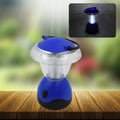 Indo Glow Mini Camping Lantern hanging from a tent pole, illuminating a campsite at dusk.