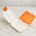 Open pill organizer box displaying 8 compartments for sorting pills