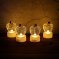 Set of four golden apple LED tealight candles glowing warmly.