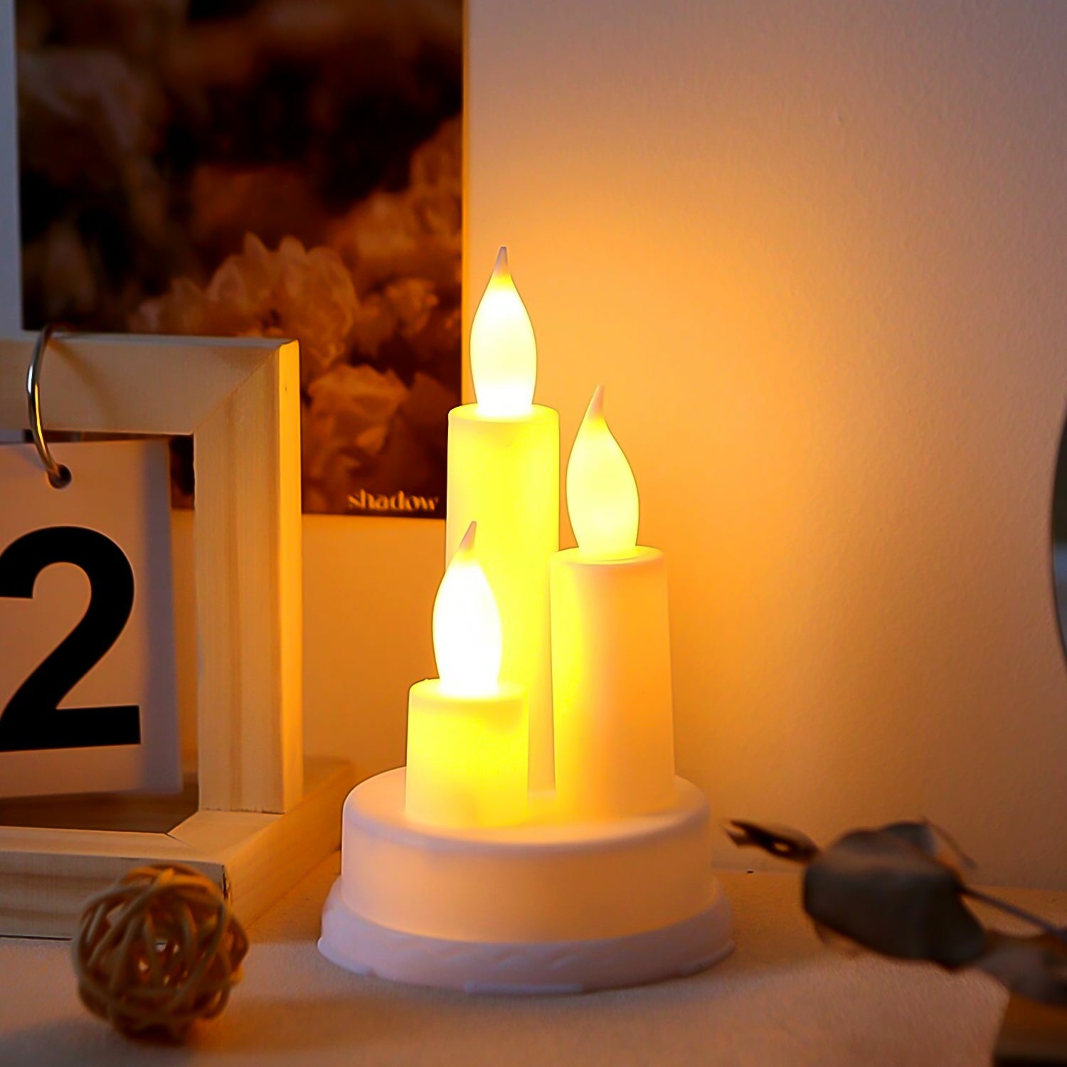 A pair of realistic LED taper candles flickering with warm white light, perfect for home decor.