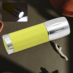 A compact Mini LED Flashlight held in hand, showing its bright beam in the dark.