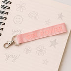 Girl Power fabric ribbon keychain with vibrant pink embossed strap on metal ring