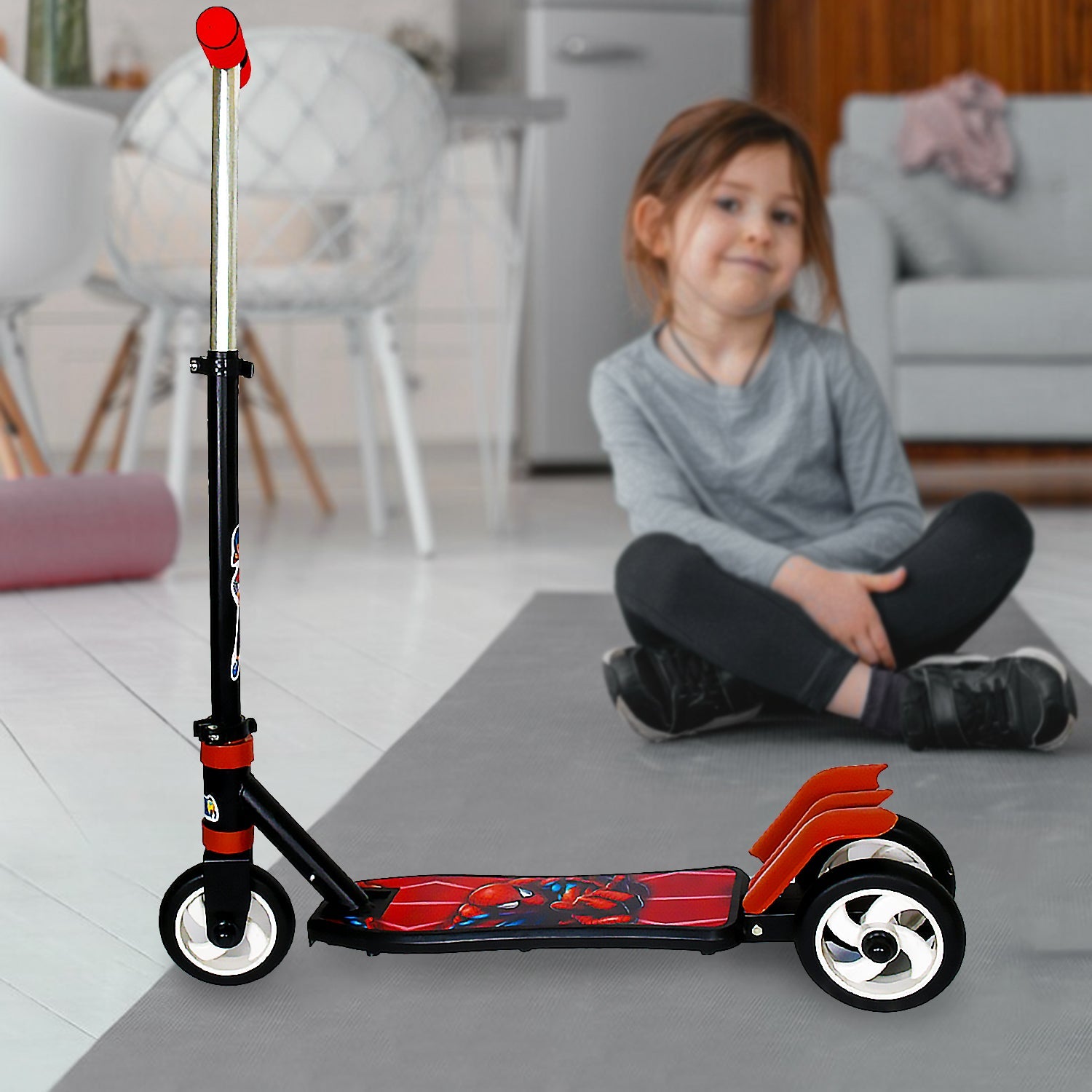 A young boy riding a bright, multi-coloured 3-wheel scooter with enthusiasm.