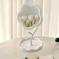 Flower-shaped makeup mirror providing clear reflection with integrated tray for essentials
