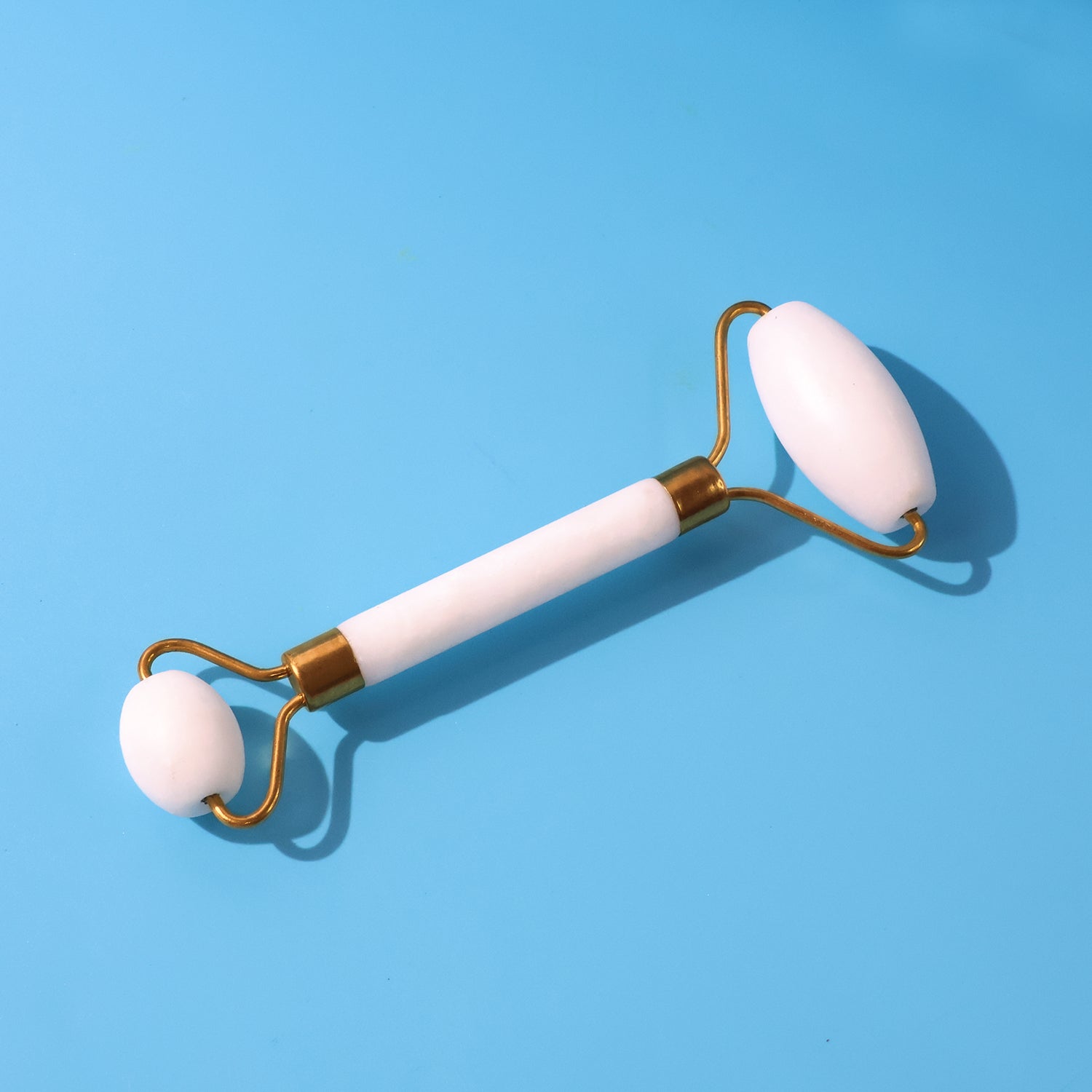 Dual-ended face massage roller with cooling stone heads on a clean background.