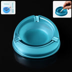 Transparent plastic ashtray with three cigarette rest slots and wide bowl