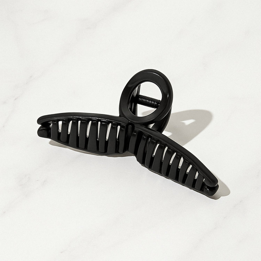 Person styling hair effortlessly with a strong, non-slip hair claw clip