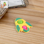 Yellow, green, and pink rocket-shaped fidget keychain toy with tactile popper bubbles