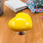 Close-up of a vibrant red heart-shaped knob, ideal for cabinets or drawers.