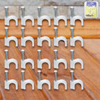 Close-up of steel nail gripping a plastic cable clip for dependable wire holding