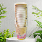 Several mixed design disposable paper cups arranged neatly on a surface for a party.