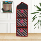 Foldable hanging organizer with three pockets shown against a white wall.