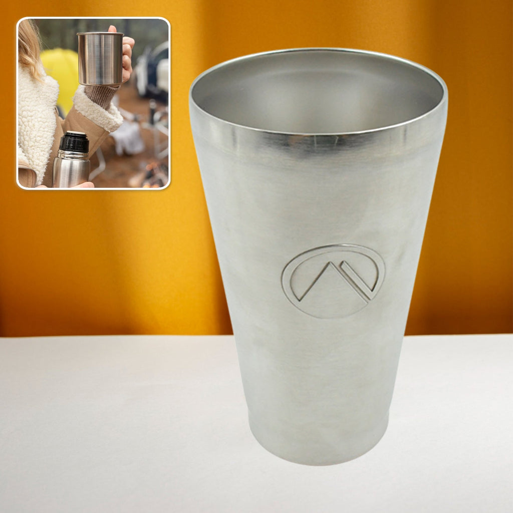 Person holding the portable stainless steel travel mug outdoors.
