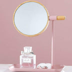 Round tabletop makeup mirror with wooden finish frame on vanity table