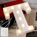 LED Marquee Alphabet Letter Light T glowing softly on table