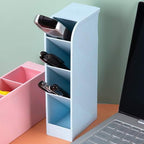 Clear plastic desktop pen holder with four compartments, neatly organising pens and pencils.
