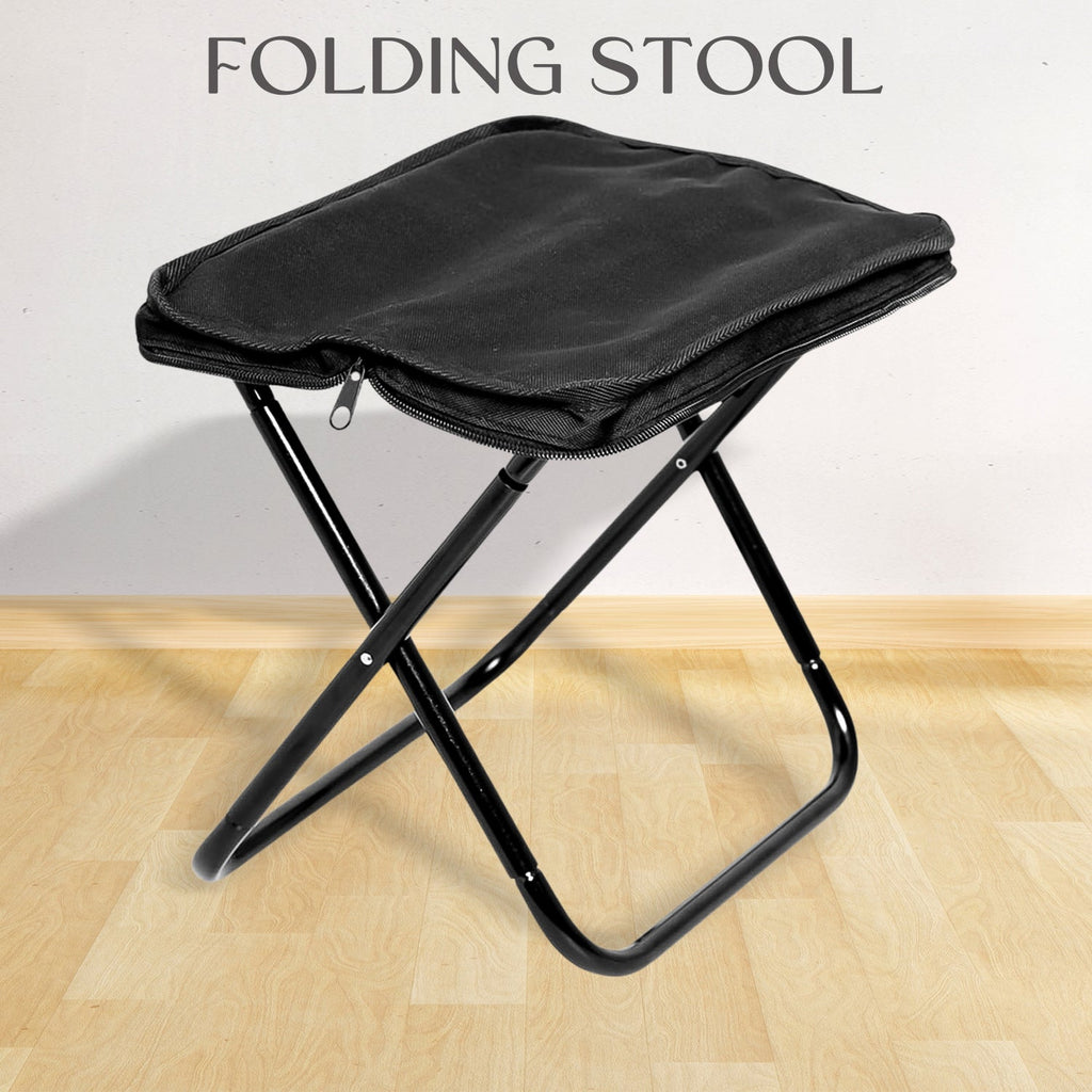 Folding Camping Stool set up in a lush green outdoor setting, ready for use.