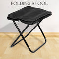 Folding Camping Stool set up in a lush green outdoor setting, ready for use.