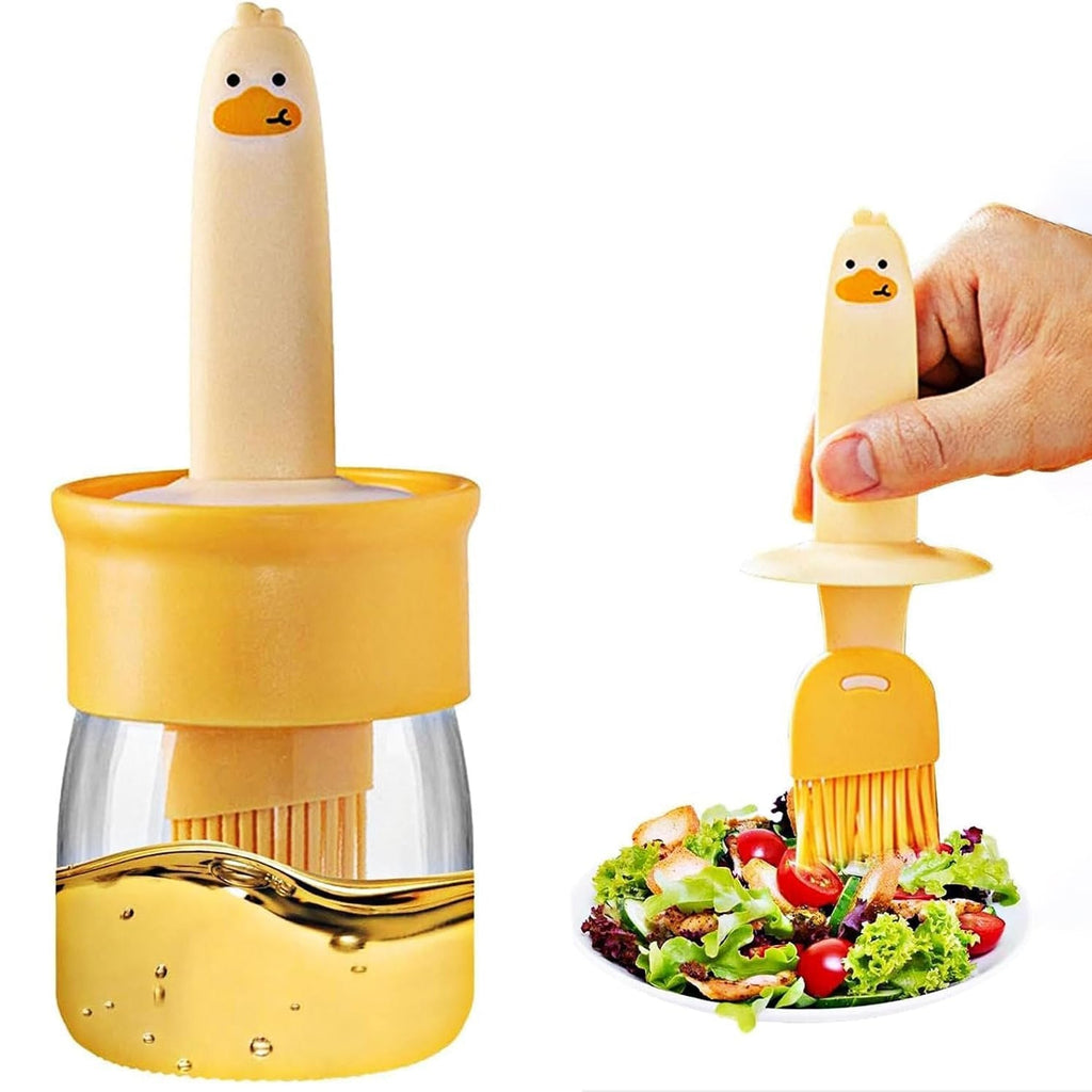 A clear plastic oil dispenser bottle with an integrated blue silicone basting brush.