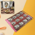 Wall-mounted stainless steel agarbatti stand with incense sticks.