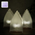 Set of three flameless LED lantern lights with frosted ribbed design emitting warm glow
