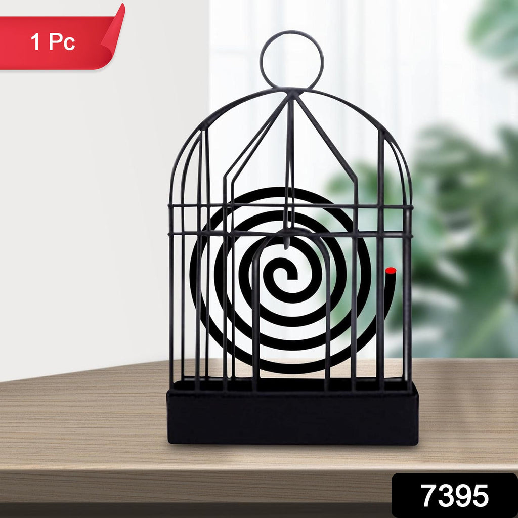 Iron birdcage mosquito coil holder placed on a rustic wooden table.