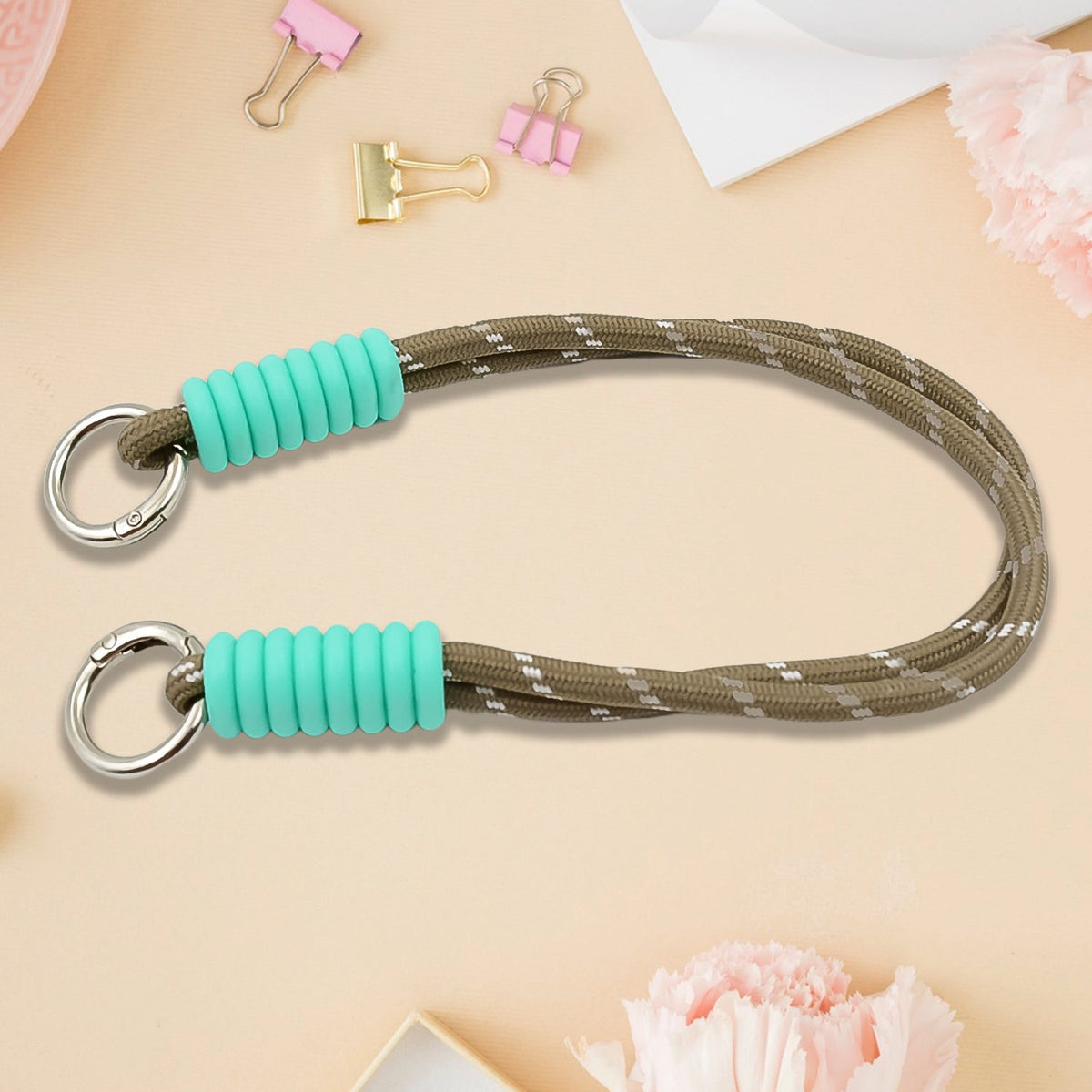 A phone with a vibrant multi-colored phone wrist strap attached, held securely.