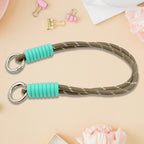 A phone with a vibrant multi-colored phone wrist strap attached, held securely.
