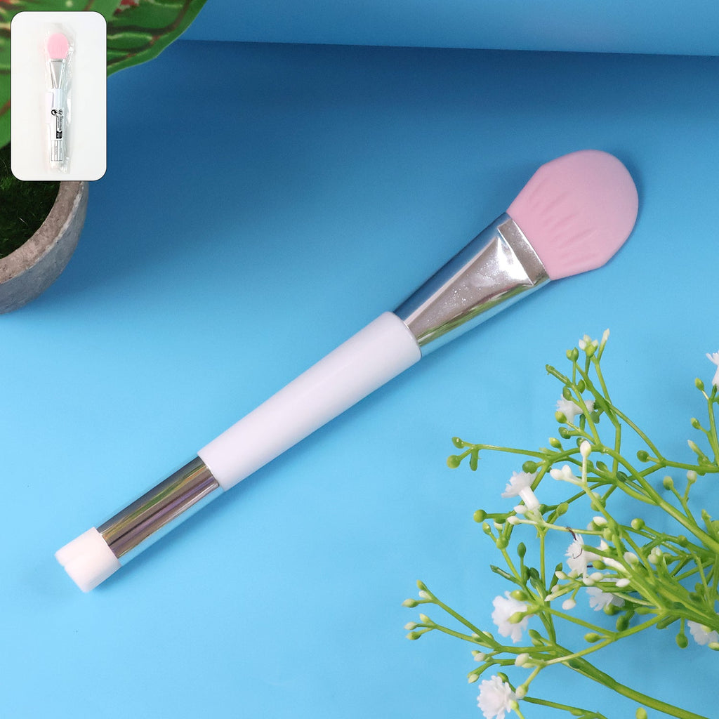 Silicone face mask applicator beauty brush resting on white surface