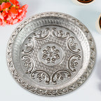 Detailed close-up of silver finish plastic pooja thali with embossed patterns