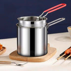 Delicious crispy fries freshly cooked and draining in the deep frying pot's strainer basket.